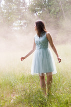 girl in a dress standing in a field 