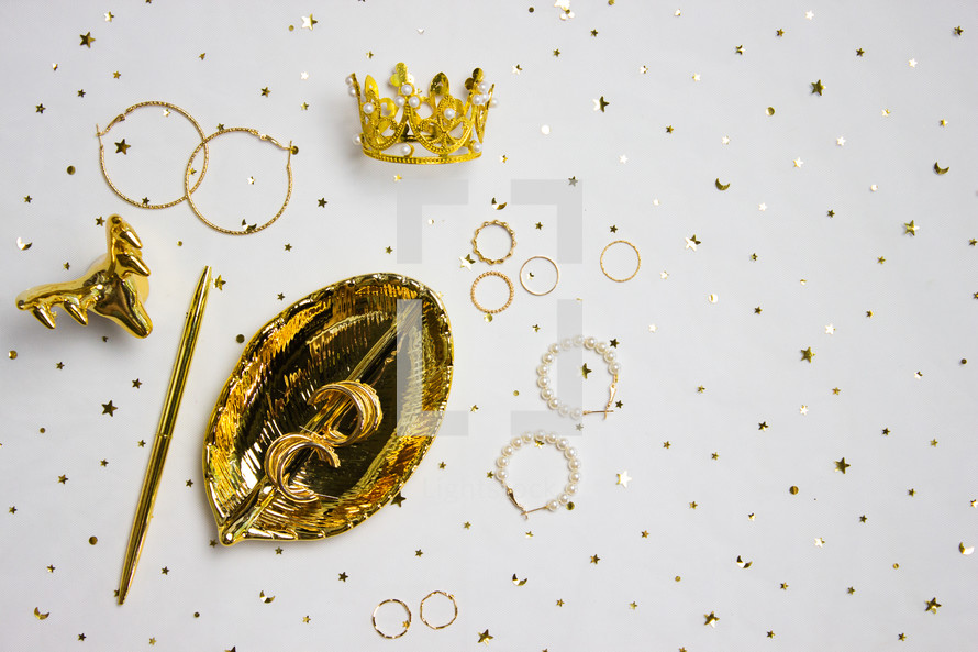 Gold jewelry and holder with gold confetti