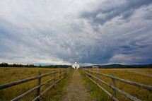 Pathway to a small country church under stormy sky