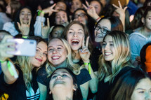 teen girls taking a selfie in the crowd at a youth conference 