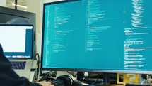 computer programmer sitting in front of a screen coding software