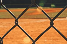 baseball field through a chain linked fence