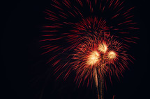 Red and gold fireworks exploding in the night sky.