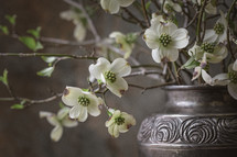 Small, white flowers in silver vase