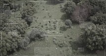 Surveillance drone view of soldiers walking through a forest with hud graphics