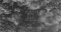 Military drone night vision thermal view of soldiers walking through a forest