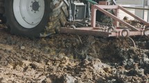 Tractor plowing Manure in a dairy farm shed