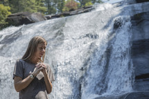 praying in front of a waterfall in Asheville, NC 