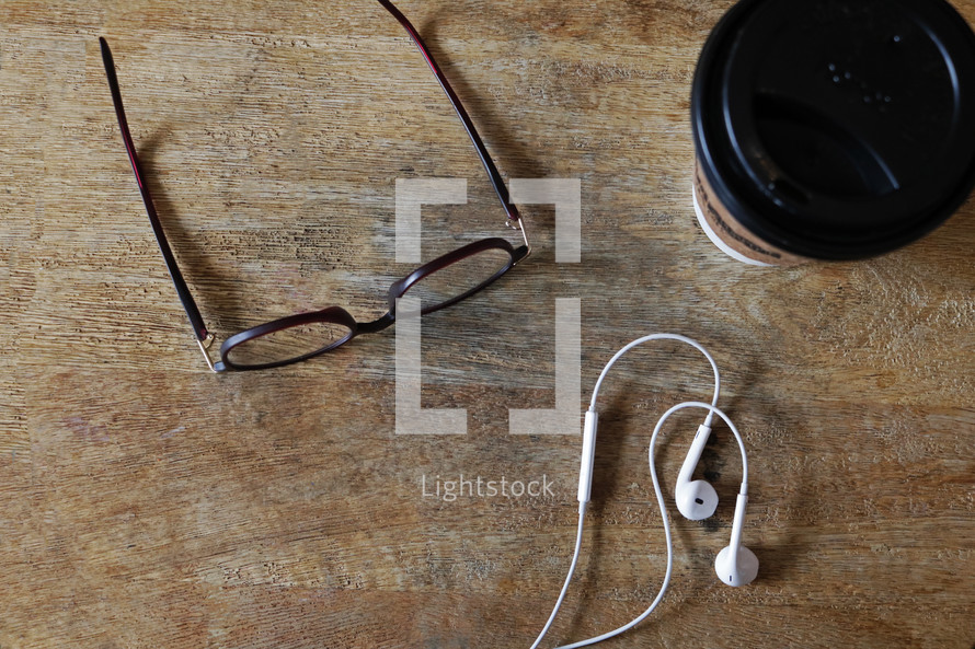 reading glasses, earbuds, and coffee cup 
