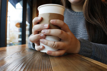 a young woman holding a coffee cup 