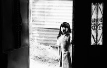 Girl looking through an open door