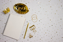 Gold jewelry and holder with gold confetti and notebook
