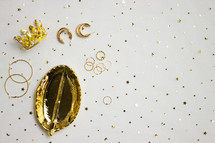 Gold jewelry and holder with gold confetti
