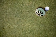 golf ball going into the hole 