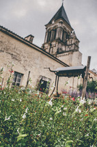 flowers and well in front of a church in France 