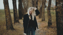 a blonde woman standing outdoors in fall 
