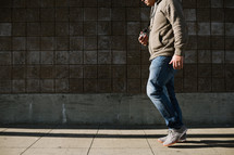 man walking on a sidewalk holding a camera 