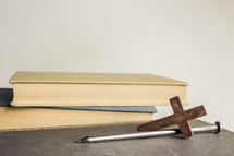 nail and cross next to books 