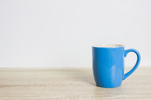 blue mug on a wood table 