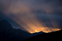 rays of light behind a mountain at sunrise 