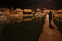 dock and huts in a village near water at night 