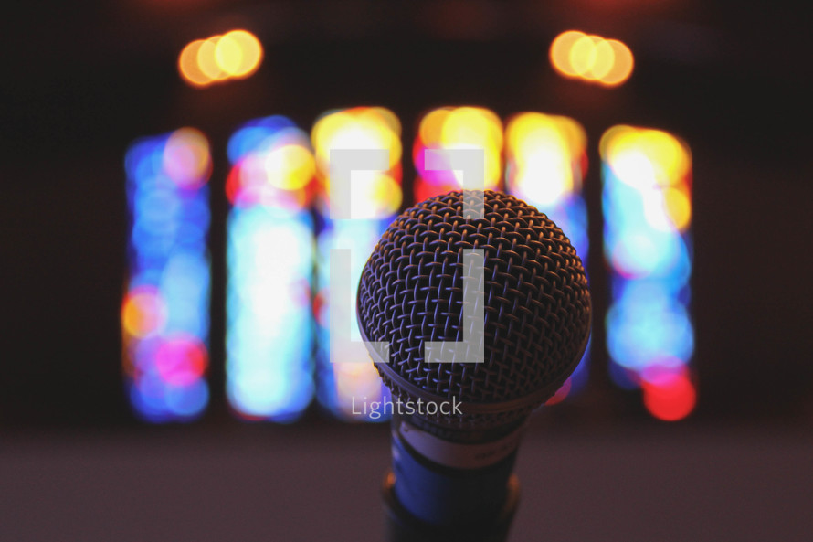 Microphone in front of stained glass window.