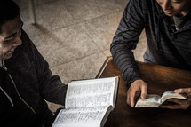 Two men reading at a Bible study.