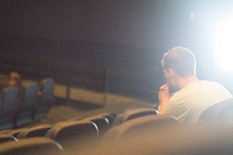 man sitting in an empty church in prayer 