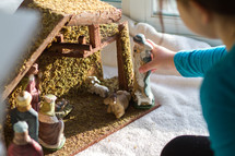 child playing with a nativity scene 