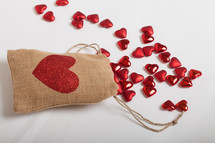 red hearts, burlap sac, on a white background 