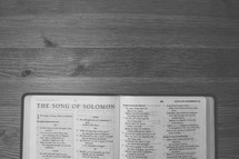 Bible on a wooden table open to the Song of Solomon.
