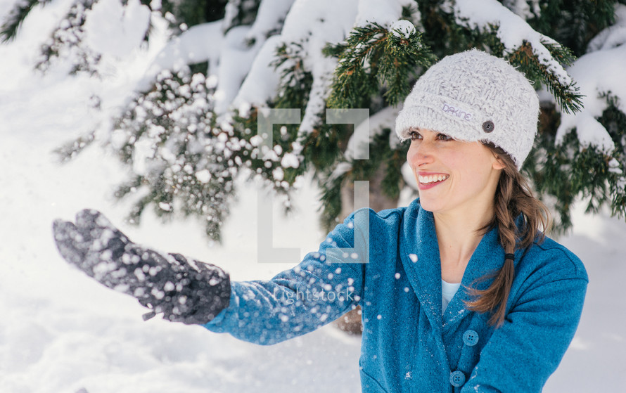 woman wearing gloves playing in snow 