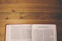 Bible on a wooden table open to the book of Zechariah.