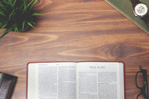 open Bible and reading glasses on a wood table - Malachi 