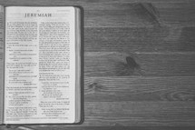 Bible on a wooden table open to the book of Jeremiah.