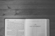 Bible on a wooden table open to the Old Testament.