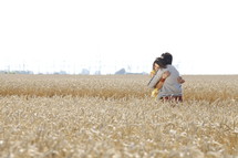 A man and woman embracing in a field of grain.
