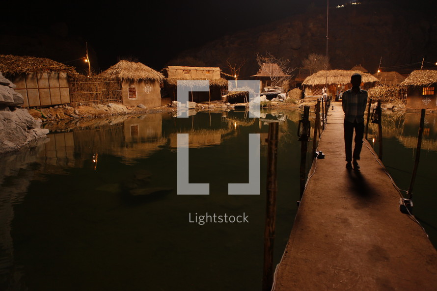 dock and huts in a village near water at night 