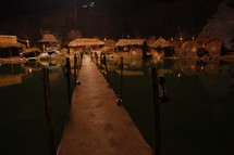 dock and huts in a village along water at night 
