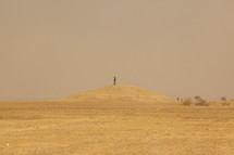 standing on hill in a desert