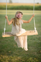 A young girl sitting on a swing