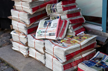 Stacks of newspapers tied up on the ground