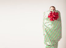 A man covered with wrapping paper and bow