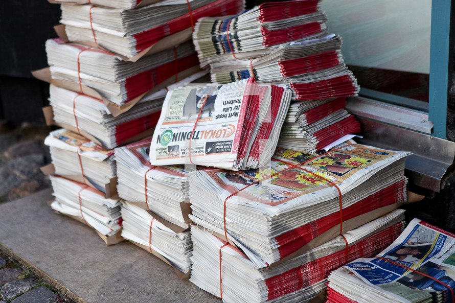 Stacks of newspapers tied up on the ground