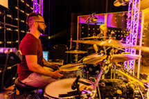 A drummer in a sound studio on stage live worshipping  eyes closed 