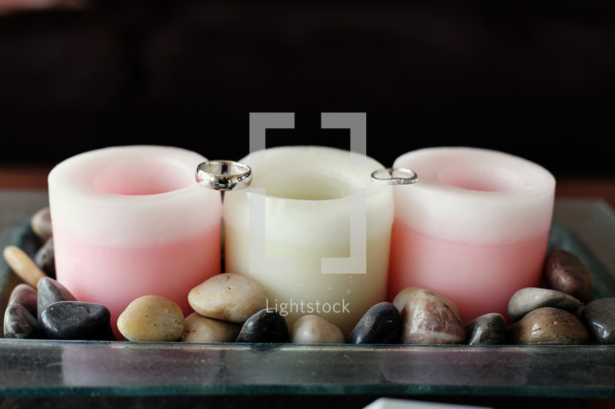 Wedding rings sitting on candles
