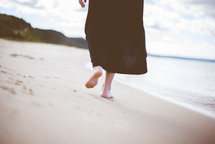 a woman walking on a beach 
