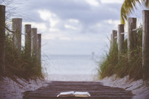 opened Bible on a beach boardwalk 