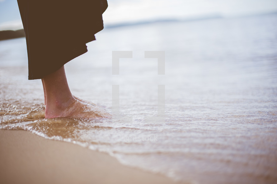 tide washing over bare feet 