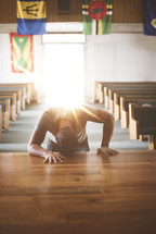 a man praying alone at an altar in a church 